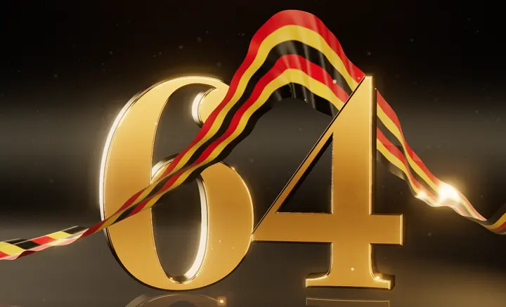 A gold number 64 wrapped in a silk ribbon in Uganda’s black, yellow and red